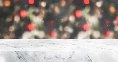 Marble table top with abstract blur christmas tree red decor ball and snow fa Stock Photos