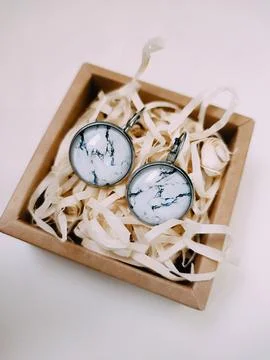 Marble texture stone earrings in small craft paper jewelry box, jewelry Foto stock