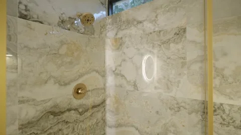 Marble tile in beige and grey colours on walls of shower cabin with tiny window Stock Footage 282284801