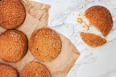 On a marble white table, sandy round cookies, one broken, top view, close-u.. Stock Photos