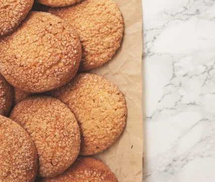 On a marble white table, sandy round cookies, one broken, top view, close-up. Stock Photos