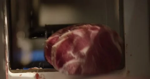 Marbled piece of raw meat lying in the feed chute of an industrial meat slicing Vídeo Stock 339980667
