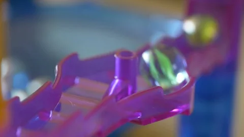 Marbles going down a bumpy purple chute. Stock Footage 109160111