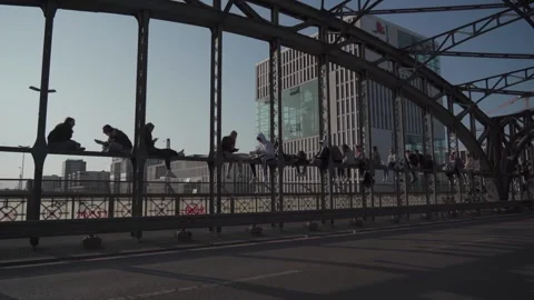 March 18, 2022. Munich, Germany Hackerbrucke. People relax sitting on bridge Stock Footage 258250982