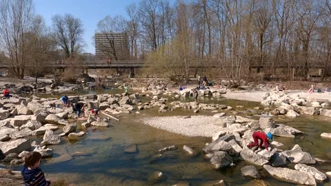 March 22, 2022. Munich, Germany. Cyclists ride on cycle path along Isar River in Stock Footage 294694701