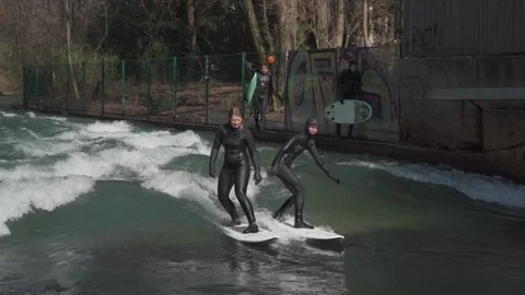 March 25, 2022. Munich, Germany. Surfers surfing an River Isar in English Stock Footage 294695871