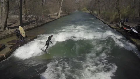 March 28, 2022. Munich, Germany. Eisbachwelle am Englischen Garten. Surfing am Stock Footage 294695589