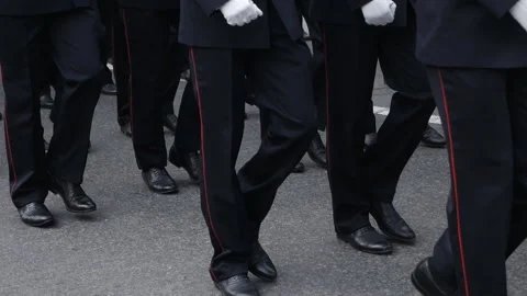 The marching legs of a group of men in blue uniforms during an afternoon parade Stock Footage 156412859