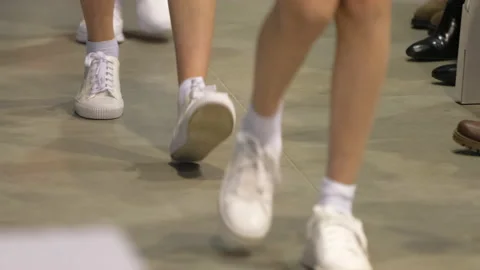 Marching sporting legs in white sneakers. Athletic footwear fashion show stage. Video stock 160244282