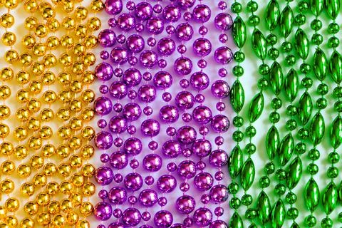 Mardi Gras background. Multi-colored beads close-up. Festive decorations in g Stock Photos