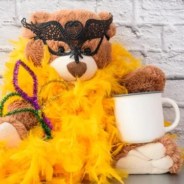 Mardi Gras Mockup. Empty blank white coffee mug and Teddy bear in mask and boa Stock Photos