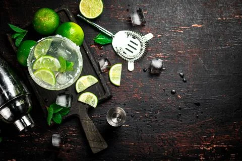 Margarita on a cutting board with pieces of lime and mint leaves. Stock Photos