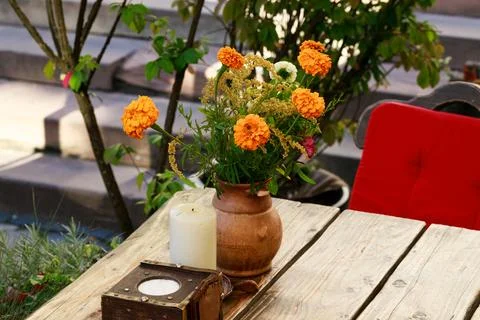 Marigold flower vase decorative elements on table restaurant patio space in s Stock Photos