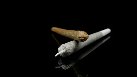 Marijuana Addiction Concept Pair of Rolled Up Weed Joints Isolated against Black Stock Footage 108590744