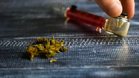 Marijuana buds lie on a dark table against a glass Smoking pipe, close up Stock Footage 115081863