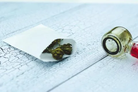 Marijuana cones lie on a light table against a glass Smoking pipe, close up Stock Photos