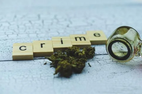 Marijuana cones lie on a light table against a glass Smoking pipe. Wooden cubes Stock Photos