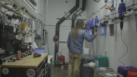 Marijuana farmer walks through hydro plumbing at grow operation. Stock Footage 82327985