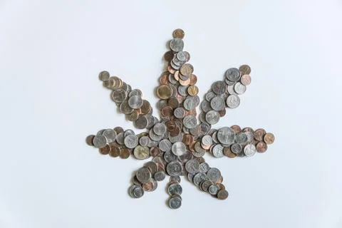 Marijuana leaf made of US American coins on solid white background Stock Photos