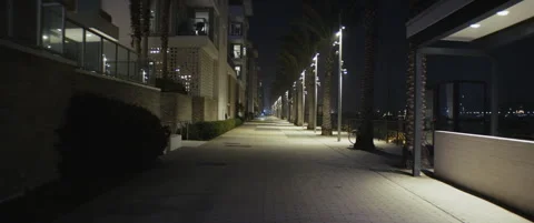 Marina at night time, down lights, apartments water framing. Camera tilts down.  Stock Footage 296296027