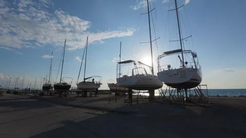 Marina yard with stored yachts under blue sky and sunset glow Vidéo 337460078