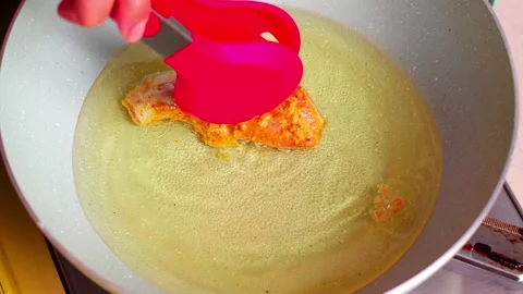 Marinated chicken being placed into hot oil Stock Footage 329836797