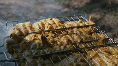 Marinated Chicken Meat Grilling on Metal Wire Rack with Smoke Outdoors Stock Footage 338086754