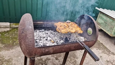 Marinated Chicken Pieces Grilling on Rusty Metal Barrel Barbecue in Backyard Stock Footage 339003638
