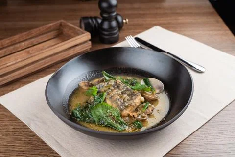 Marinated cod with stewed scallops and spinach, dressed with hazelnut sauce Stock-Fotos