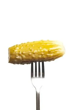 Marinated cornichon on the fork isolated on the white background Foto stock