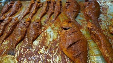 Marinated fish in tray with vibrant reddish spices 写真素材