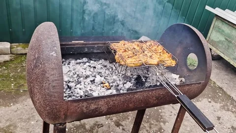 Marinated Meat Cooking in Wire Basket Over Hot Coals in Rustic Grill Stock Footage 339003742