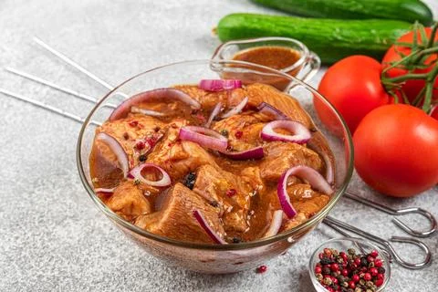 Marinated meat with fresh vegetables, bbq sauce, pepper, onion and basil in.. Stock Photos