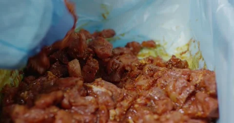 Marinated meat pieces with spices inside an open plastic bag, Food Factory Stock-Footage 340031233