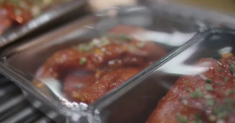 Marinated meat in red spice sauce topped with chopped herbs lying in black Vídeo Stock 340001561