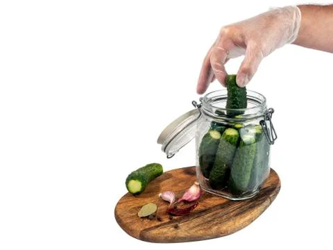 Marinated, pickled cucumbers in a glass jar on a wooden board Stock Photos