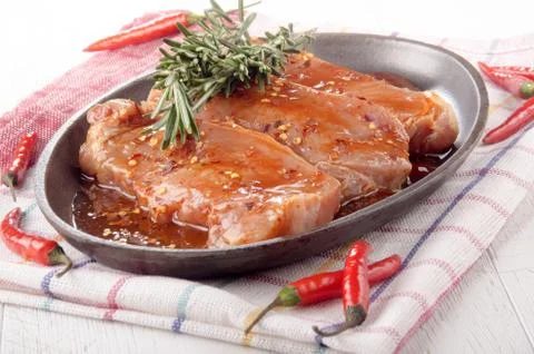 Marinated pork chops in a pan Stock Photos