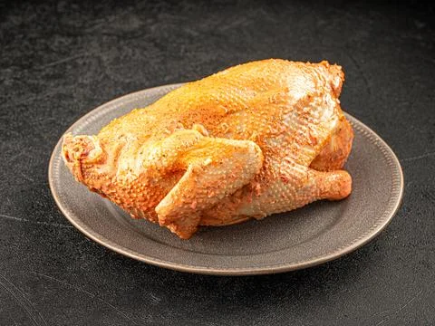 Marinated whole chicken on a plate Stock Photos