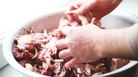Marinating meat with spices,close-up men arms mix meat in a bowl, preparation of Stock Footage 167835557