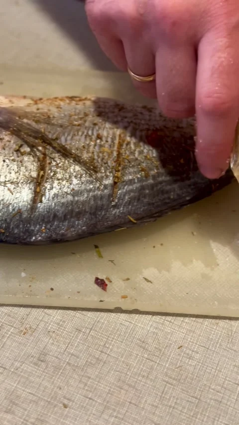 Marinating Sea Bream Fish with Herbs and Spices Close Up Stock Footage 337181950