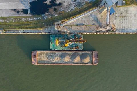 Marine cranes at the pier ready for loading bulk cargo onto a barge. Stock Photos