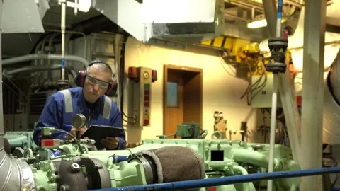 Marine Engineer in blue overall working in Engine room of ship. Work at sea. Stock Footage 275081557