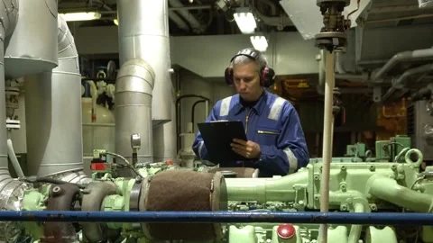 Marine Engineer in blue overall working in Engine room of ship. Work at sea. Stock Footage 275081580
