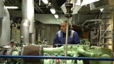 Marine Engineer in blue overall working in Engine room of ship. Work at sea. Stock Footage 275081592
