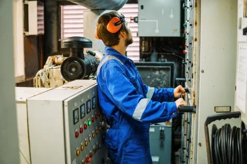 Marine engineer inspecting ship's engine or generators Stock Photos