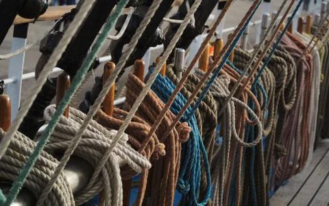 Marine ropes attached to rigging on deck of a tall ship Stock Photos