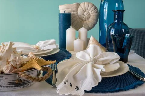Marine style table setting - shells, starfish and blue glassware Stock Photos