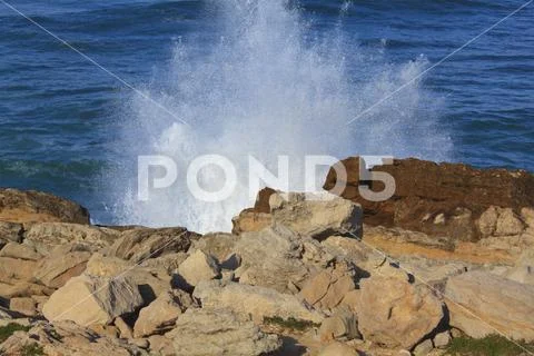 Marine wave breaks against offshore stone Stock Photos