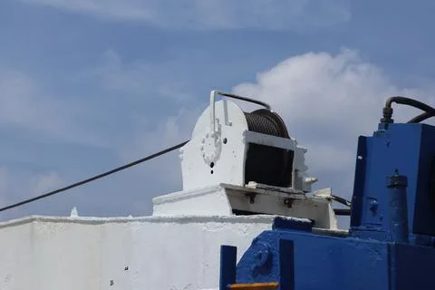 Marine Winch and Cable System on Vessel Deck Under Cloudy Sky 스톡 사진