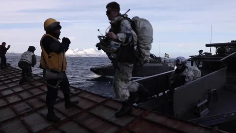Marines exiting cabin of Combat Boat onto dock landing ship USS Gunston Hall Stock Footage 266893965